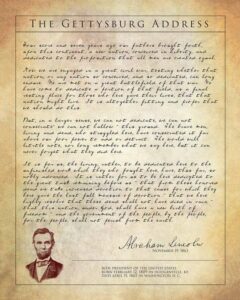 A parchment-style document displaying the Gettysburg Address with Abraham Lincolns portrait, his signature, and biographical details at the bottom. The text begins: Four score and seven years ago….